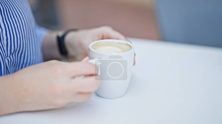 Téléchargez les photos : Jeune belle femme hispanique tenant une tasse de café assis sur la table à la terrasse du café - en image libre de droit
