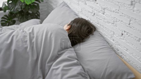 Foto de Joven mujer hispana hermosa acostada en la cama durmiendo en el dormitorio - Imagen libre de derechos