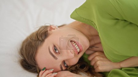 Photo for Young blonde woman smiling confident lying on bed at bedroom - Royalty Free Image