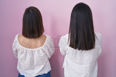 Photo for Hispanic mother and daughter together standing backwards looking away with crossed arms - Royalty Free Image