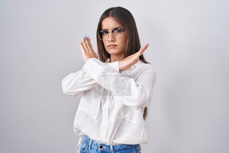 Photo for Young brunette woman wearing glasses rejection expression crossing arms doing negative sign, angry face - Royalty Free Image