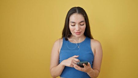 Photo for Young beautiful hispanic woman using smartphone smiling over isolated yellow background - Royalty Free Image