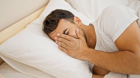 Photo for Young hispanic man lying on bed crying at bedroom - Royalty Free Image