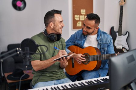 Téléchargez les photos : Deux musiciens hommes composant une chanson jouant de la guitare classique au studio de musique - en image libre de droit