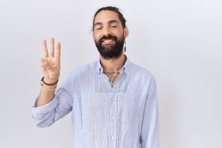 Téléchargez les photos : Hispanic man with beard wearing casual shirt showing and pointing up with fingers number three while smiling confident and happy. - en image libre de droit
