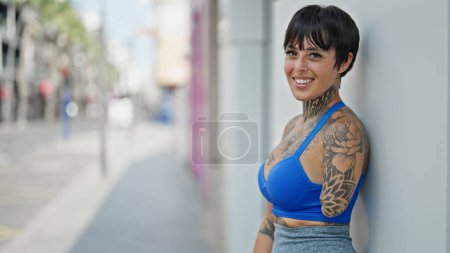 Téléchargez les photos : Femme hispanique avec le bras amputé souriant confiant debout dans la rue - en image libre de droit