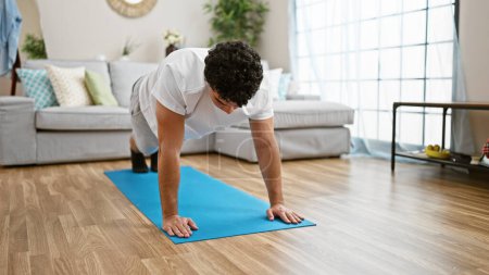 Photo for Young latin man training core exercise at home - Royalty Free Image