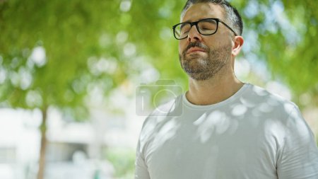 Téléchargez les photos : Homme aux cheveux gris respirant les yeux fermés au parc - en image libre de droit