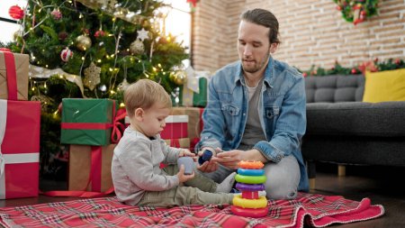 Téléchargez les photos : Père et fils célébrant Noël jouant avec des jouets à la maison - en image libre de droit