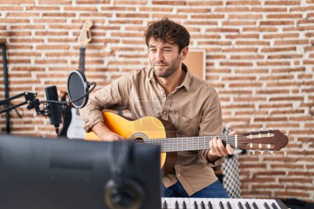 Photo for Young man musician playing classical guitar at music studio - Royalty Free Image