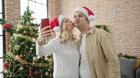 Foto de Hombre y mujer pareja celebrando la Navidad hacen selfie por teléfono inteligente en casa - Imagen libre de derechos