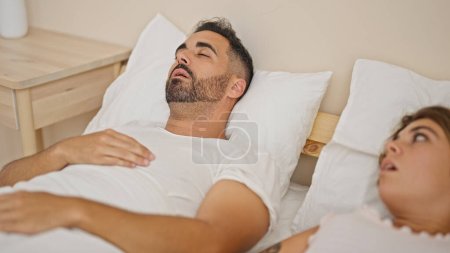 Téléchargez les photos : Homme et femme couple couché sur le lit stressé pour ronfler dans la chambre - en image libre de droit