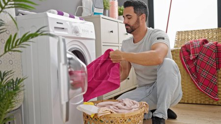 Foto de Joven hispano lavando ropa en la lavandería - Imagen libre de derechos