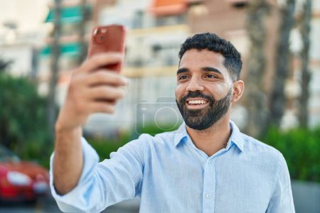 Photo for Young arab man smiling confident making selfie by the smartphone at street - Royalty Free Image