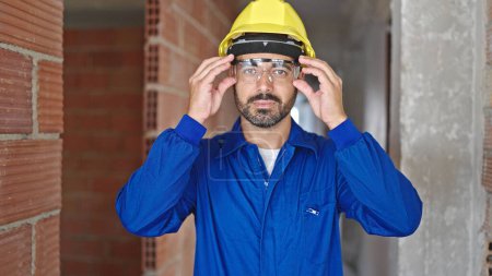 Téléchargez les photos : Jeune ouvrier hispanique portant des lunettes sur le chantier - en image libre de droit