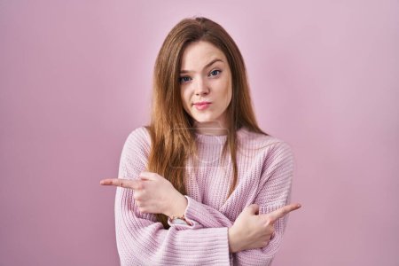 Téléchargez les photos : Jeune femme caucasienne debout sur fond rose pointant des deux côtés avec les doigts, direction différente en désaccord - en image libre de droit