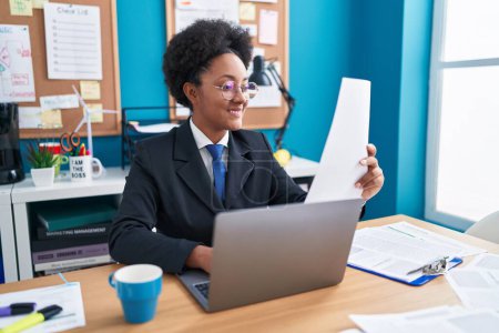 Photo for African american woman business worker using laptop reading document at office - Royalty Free Image