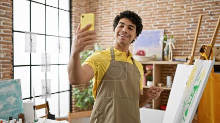 Photo for Young latin man artist smiling confident having video call at art studio - Royalty Free Image