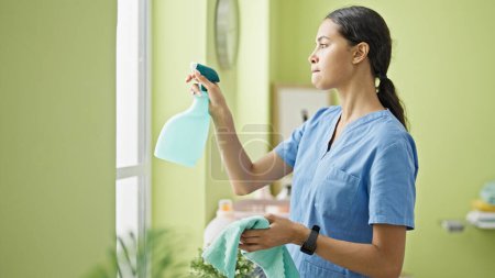 Foto de Mujer afroamericana limpiador profesional ventana de limpieza en la sala de lavandería - Imagen libre de derechos