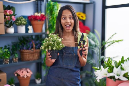 Photo for Hispanic young woman working at florist shop celebrating crazy and amazed for success with open eyes screaming excited. - Royalty Free Image