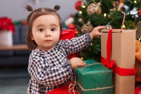Photo for Adorable chinese toddler decorating christmas tree at home - Royalty Free Image