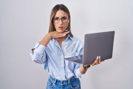 Foto de Mujer joven que trabaja con computadora portátil cortar la garganta con la mano como cuchillo, amenazan la agresión con la violencia furiosa - Imagen libre de derechos