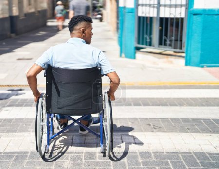Foto de Joven latino sentado en silla de ruedas en la calle - Imagen libre de derechos