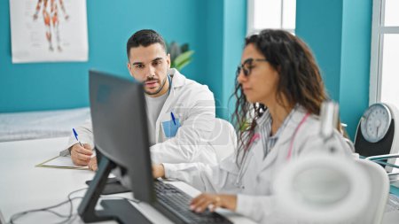 Téléchargez les photos : Médecins hommes et femmes utilisant l'ordinateur prenant des notes parlant à la clinique - en image libre de droit