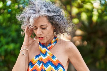 Téléchargez les photos : Middle age grey-haired woman standing with doubt expression at park - en image libre de droit
