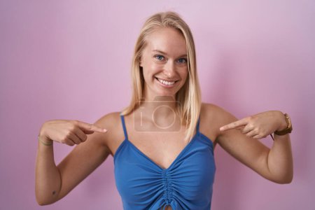 Photo for Young caucasian woman standing over pink background looking confident with smile on face, pointing oneself with fingers proud and happy. - Royalty Free Image