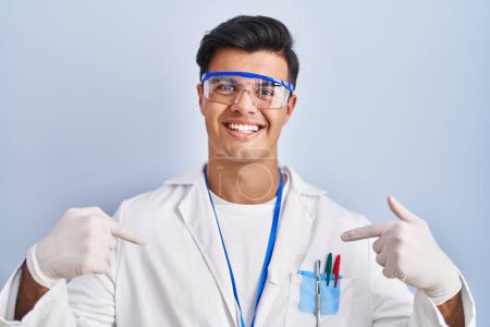 Photo for Hispanic man working as scientist looking confident with smile on face, pointing oneself with fingers proud and happy. - Royalty Free Image