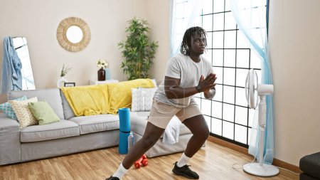 Photo for African american man training leg exercise at home - Royalty Free Image