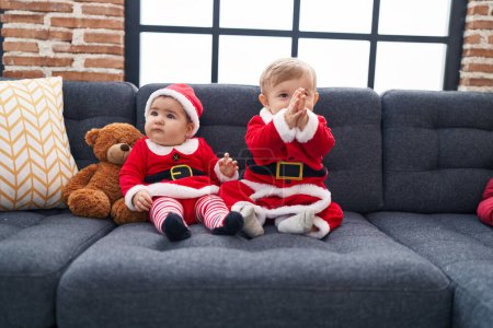 Photo for Adorable boy and girl wearing christmas clothes clapping hands at home - Royalty Free Image