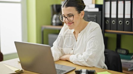 Foto de Joven hermosa mujer hispana trabajadora de negocios usando laptop trabajando en la oficina - Imagen libre de derechos