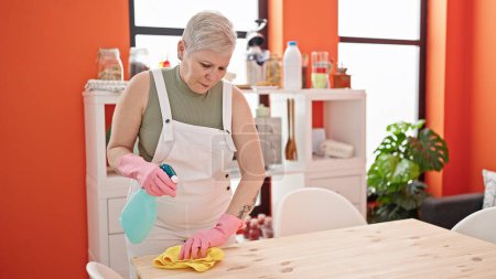 Téléchargez les photos : Table à laver femme aux cheveux gris moyen âge à la salle à manger - en image libre de droit
