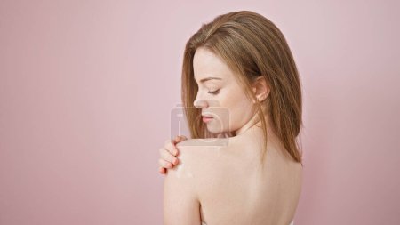 Photo for Young blonde woman smiling confident applying lotion on shoulder over isolated pink background - Royalty Free Image