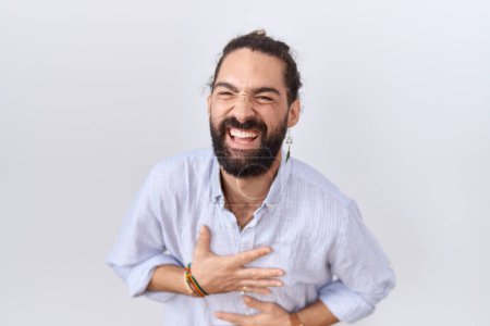Téléchargez les photos : Homme hispanique avec barbe portant chemise décontractée souriant et riant fort à haute voix parce que drôle blague folle avec les mains sur le corps. - en image libre de droit