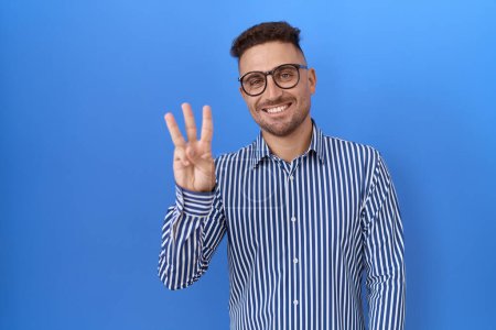 Photo for Hispanic man with beard wearing glasses showing and pointing up with fingers number three while smiling confident and happy. - Royalty Free Image