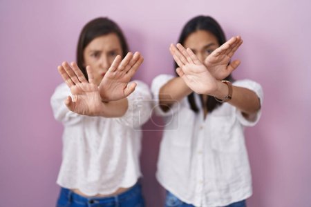 Téléchargez les photos : Mère et fille hispaniques ensemble rejet expression croisant les bras et les paumes faisant signe négatif, visage en colère - en image libre de droit
