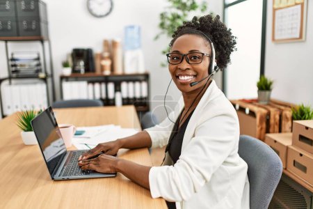Téléchargez les photos : Femme afro-américaine agent de centre d'appels souriant confiant travailler au bureau - en image libre de droit