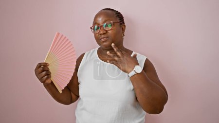 Photo for African american woman using handfan suffering for hot over isolated pink background - Royalty Free Image