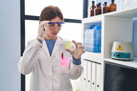 Photo for Young blonde woman scientist looking sample with serious expression at laboratory - Royalty Free Image