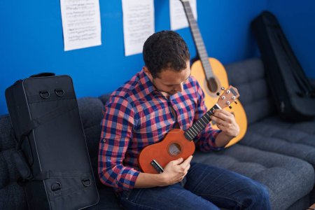 Téléchargez les photos : Jeune homme musicien jouant ukulele au studio de musique - en image libre de droit