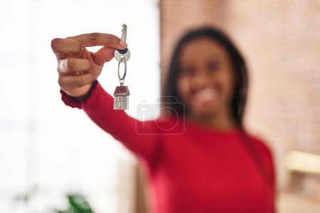 Foto de African american woman smiling confident holding key at new home - Imagen libre de derechos