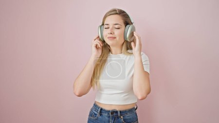 Photo for Young blonde woman listening to music smiling over isolated pink background - Royalty Free Image