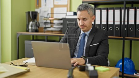 Photo for Young hispanic man business worker using laptop at office - Royalty Free Image