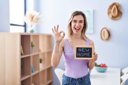 Photo for Young beautiful woman moving to a new home doing ok sign with fingers, smiling friendly gesturing excellent symbol - Royalty Free Image