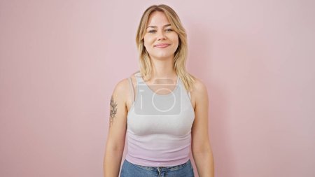 Foto de Young blonde woman smiling confident standing over isolated pink background - Imagen libre de derechos