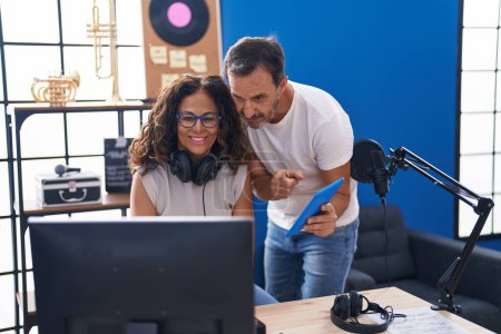 Téléchargez les photos : Man and woman musicians composing song using computer and touchpad at music studio - en image libre de droit