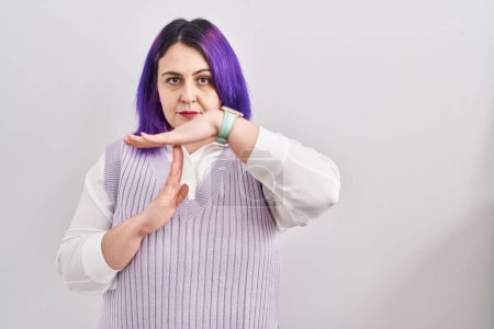 Téléchargez les photos : Plus la taille femme avec les cheveux violets debout sur fond blanc faisant un geste de temps avec les mains, frustré et sérieux visage - en image libre de droit
